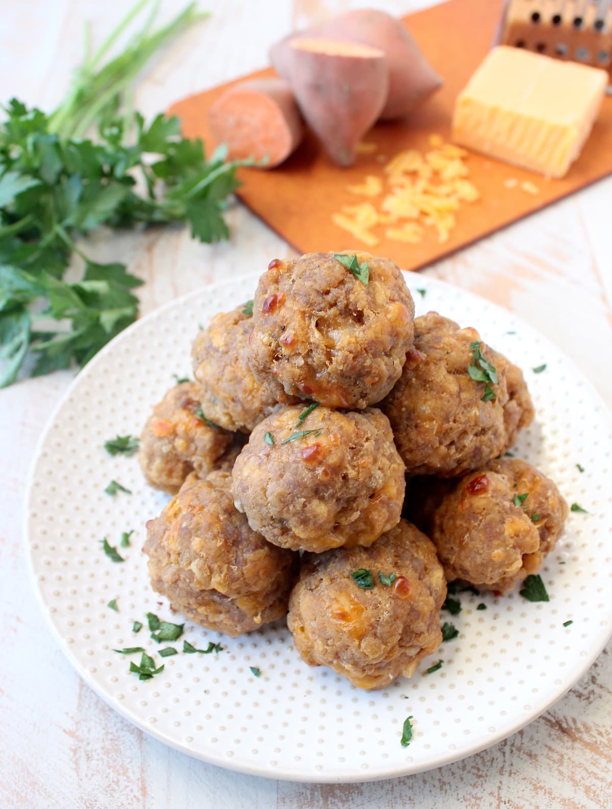 Sweet potato sausage balls on a white plate.