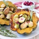Roasted acorn squash halves, filled with brussels sprouts, cranberries and fresh rosemary
