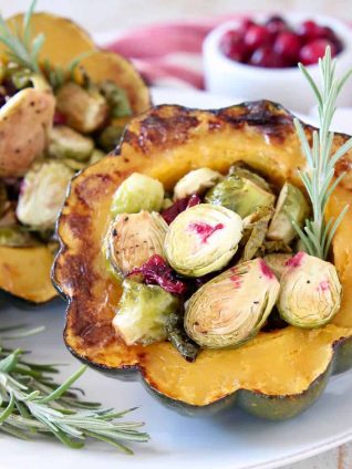 Roasted acorn squash halves, filled with brussels sprouts, cranberries and fresh rosemary