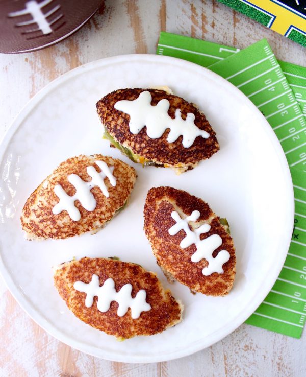 This grilled cheese sandwich recipe is filled with all of the ingredients that make a delicious jalapeño popper, cut into football shapes for game day!