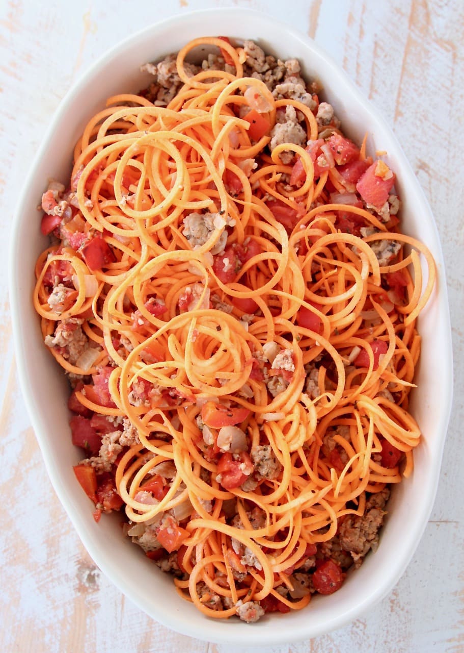 Sweet potato noodles, ground turkey and tomatoes in an oval baking dish