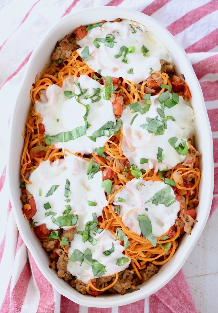 Italian casserole with sweet potato noodles, topped with mozzarella cheese in an oval baking dish