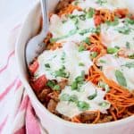 Italian casserole with sweet potato noodles and mozzarella cheese in oval white baking dish