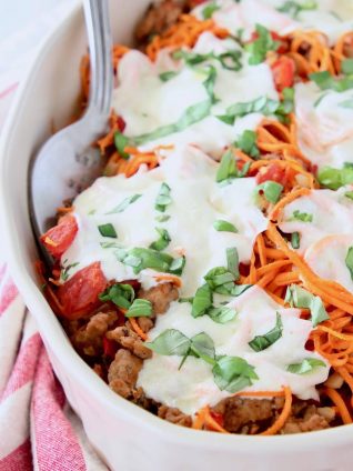 Italian casserole with sweet potato noodles and mozzarella cheese in oval white baking dish
