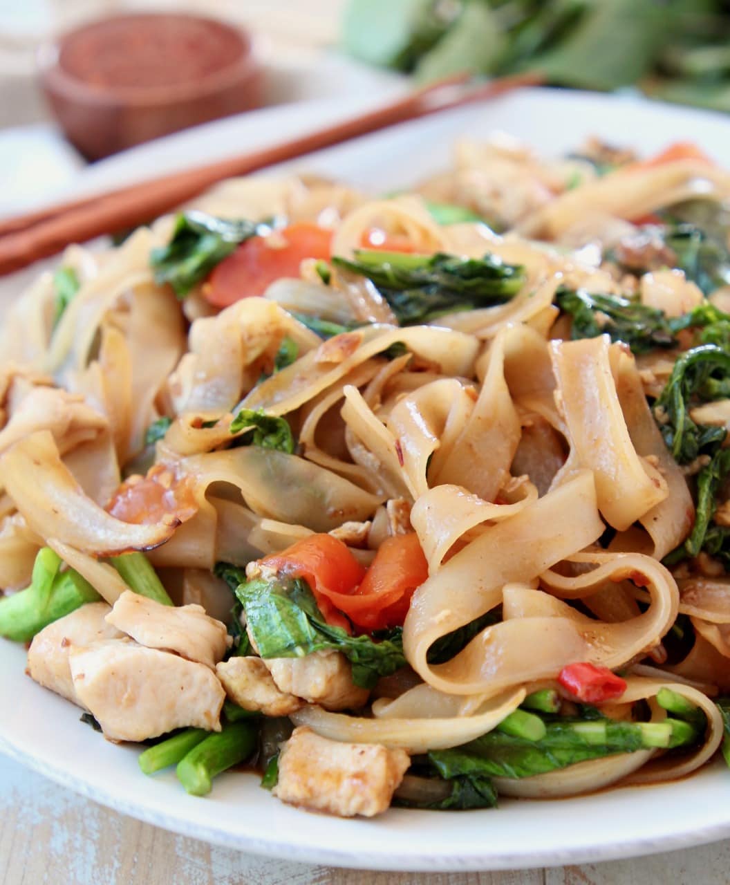 Thai wide noodles stir fried with Chinese broccoli on white plate