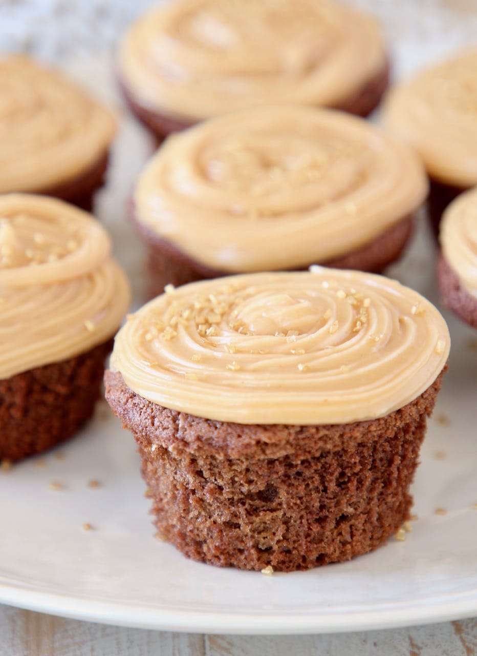 chocolate cupcakes on plate with peanut butter frosting and gold sprinkles