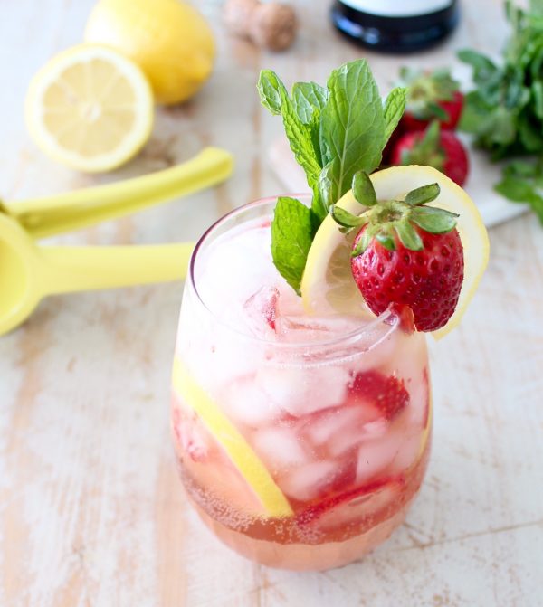 prosecco sangria in glass with strawberry, lemon and mint garnish