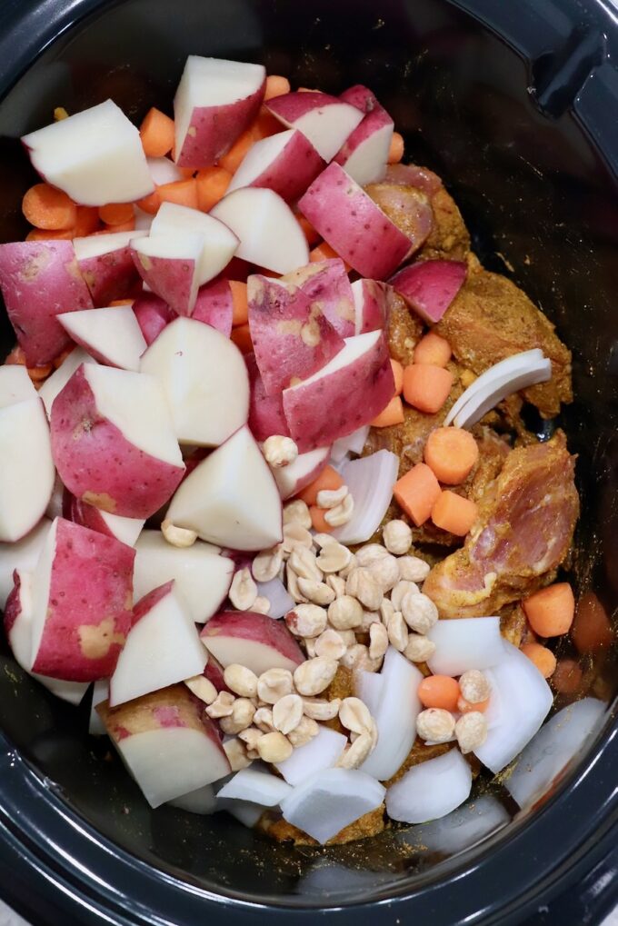 seasoned chicken in slow cooker with vegetables and peanuts