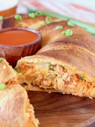 sliced into buffalo chicken ring sitting on a wood cutting board