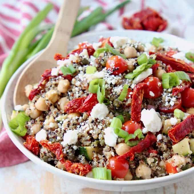 Quinoa salad in bowl with feta cheese, sun dried tomatoes and chickpeas