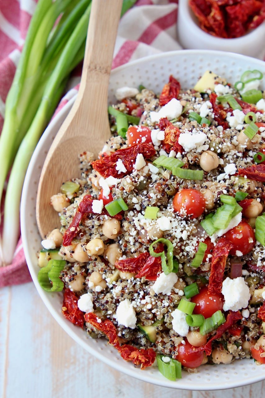 Overhead shot of quinoa salad with sun dried tomatoes, green onions and feta cheese crumbles