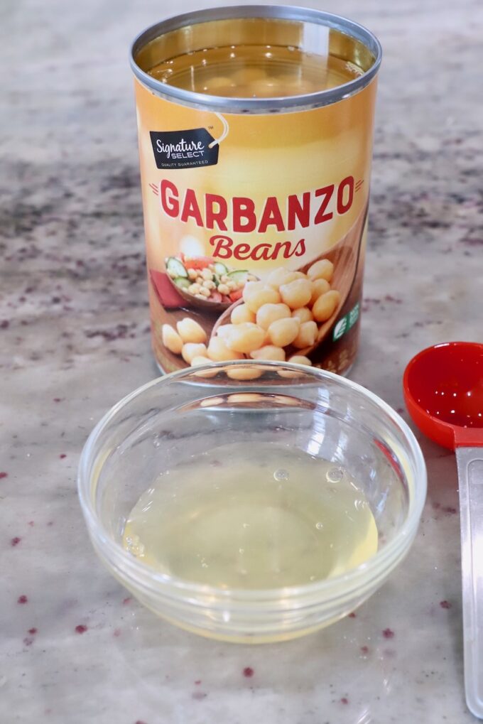 aquafaba removed from can of garbanzo beans in small glass bowl
