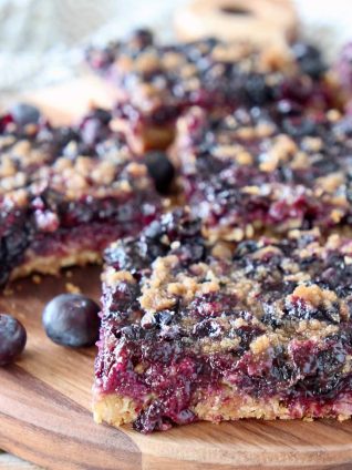 Blueberry oat bars, sliced into squares on a wood cutting board