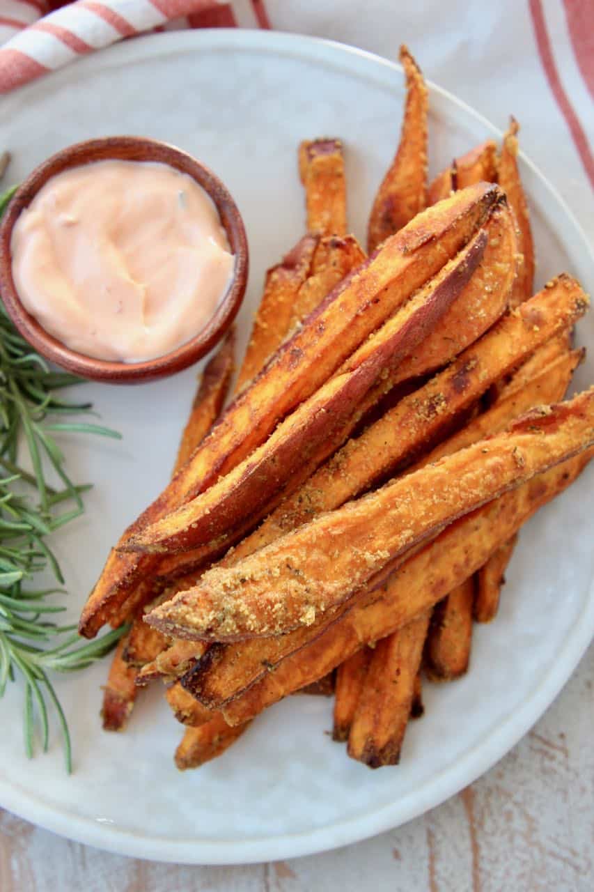 Sweet potato fries on plate with dipping sauce in a small bowl on the side