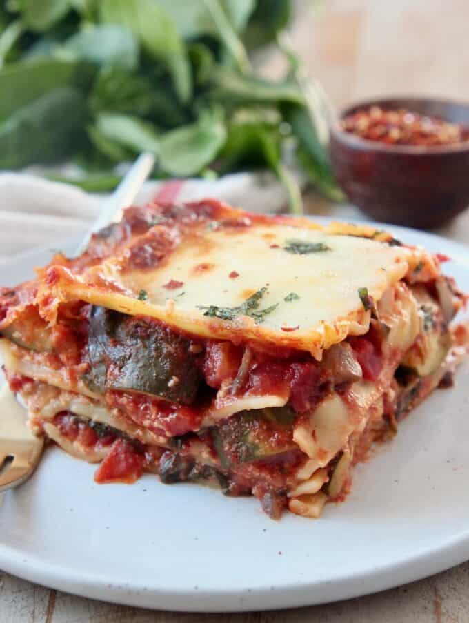 slice of vegetable lasagna on plate with fork