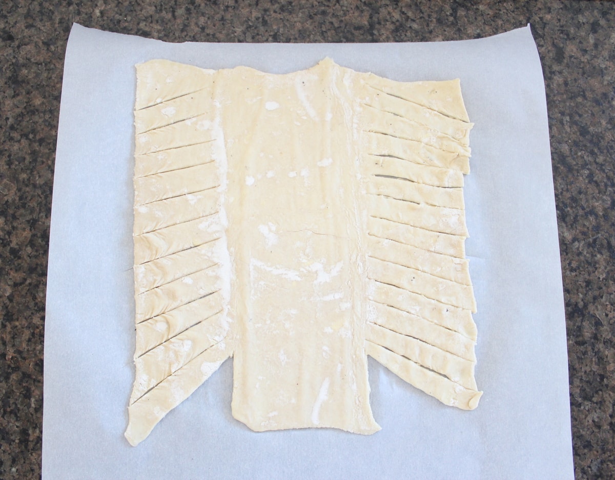 sliced puff pastry dough on parchment paper