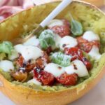 roasted spaghetti squash filled with roasted tomatoes and melted mozzarella cheese