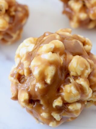 peanut butter popcorn balls on white marble serving tray