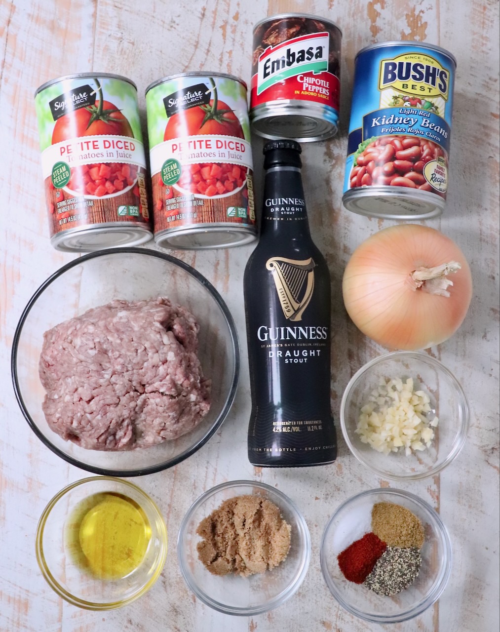 ingredients for chipotle stout chili on a white wood board