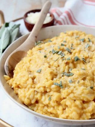 Butternut squash risotto in bowl with wooden spoon