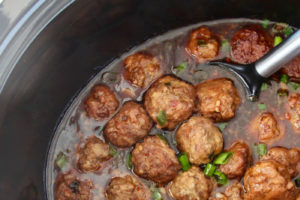 Korean BBQ Meatballs in a slow cooker with spoon, image with text overlay "slow cooker korean bbq meatballs with the best korean bbq sauce"