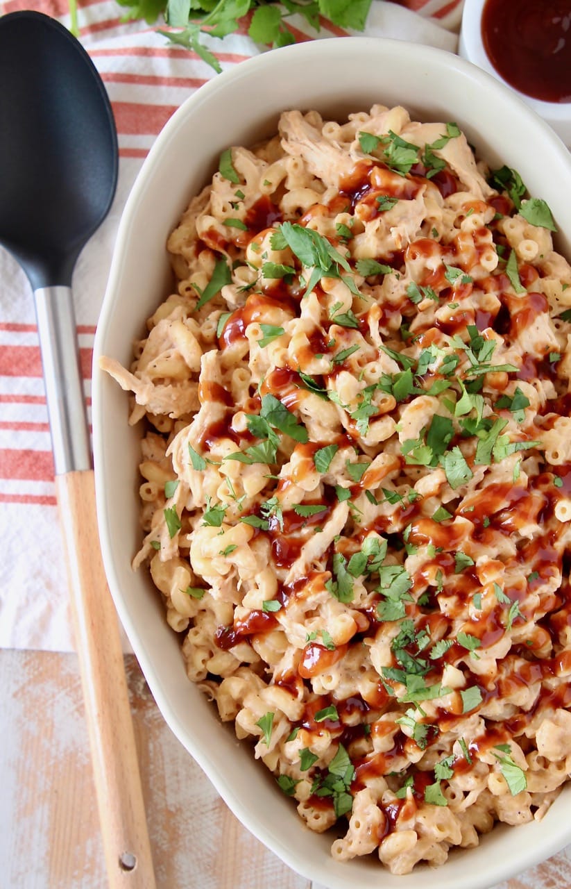 BBQ Chicken mac and cheese in large oval casserole dish topped with fresh chopped cilantro