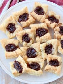 Baked puff pastry bites filled with fig jam on plate