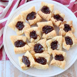 Baked puff pastry bites filled with fig jam on plate