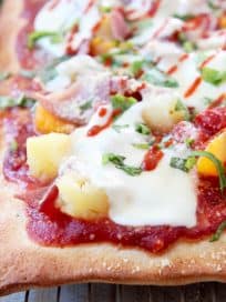Hawaiian pizza on wire baking rack topped with pineapple, mandarin oranges and mozzarella cheese