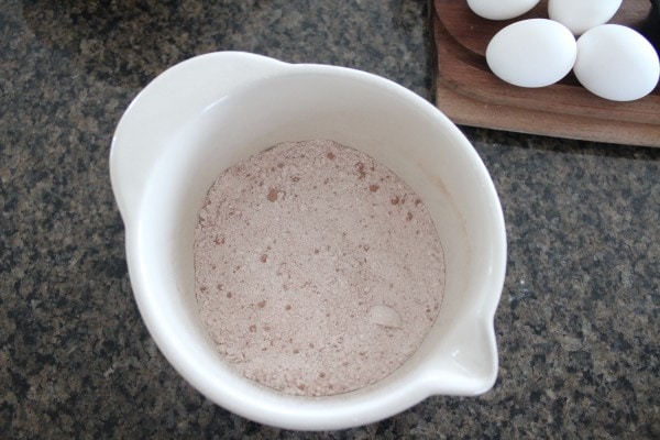 Cocoa powder, flour, salt, and baking powder mixed in a white bowl.