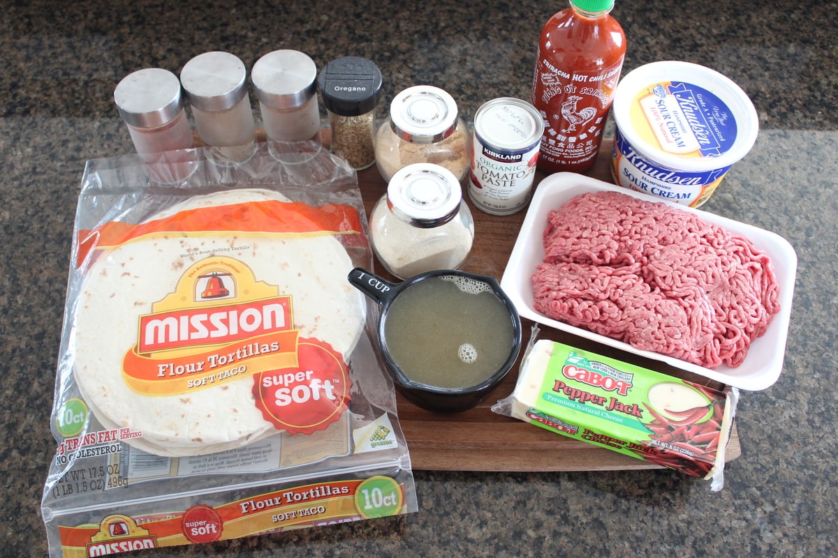 Creamy Sriracha Beef Enchilada Recipe Ingredients on a wood board