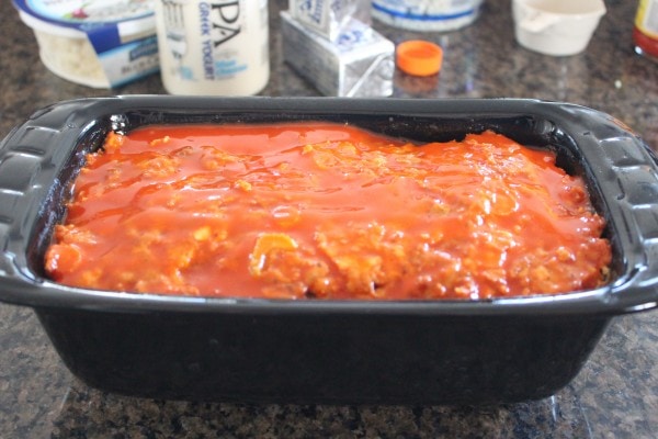 buffalo sauce on top of meatloaf in a loaf pan
