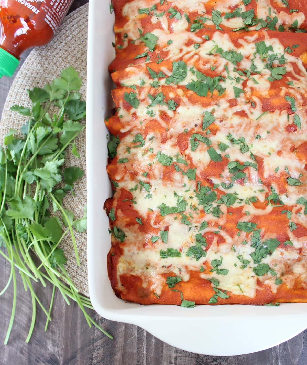 enchiladas in a baking dish topped with fresh chopped cilantro