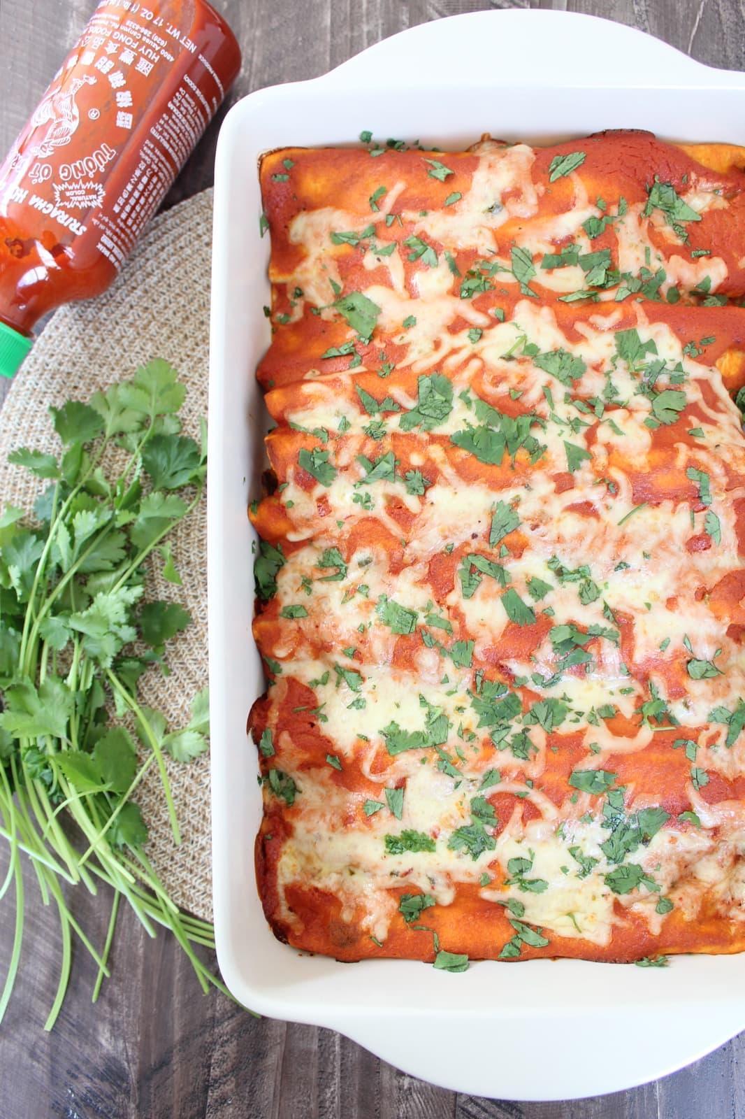 enchiladas in a baking dish with fresh cilantro