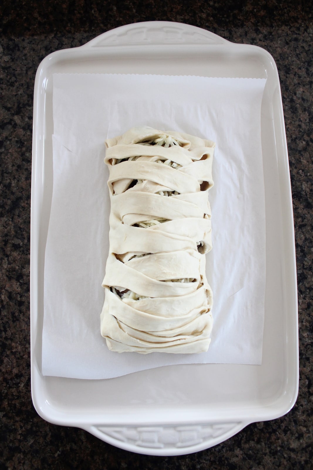 braided puff pastry dough on parchment lined baking sheet