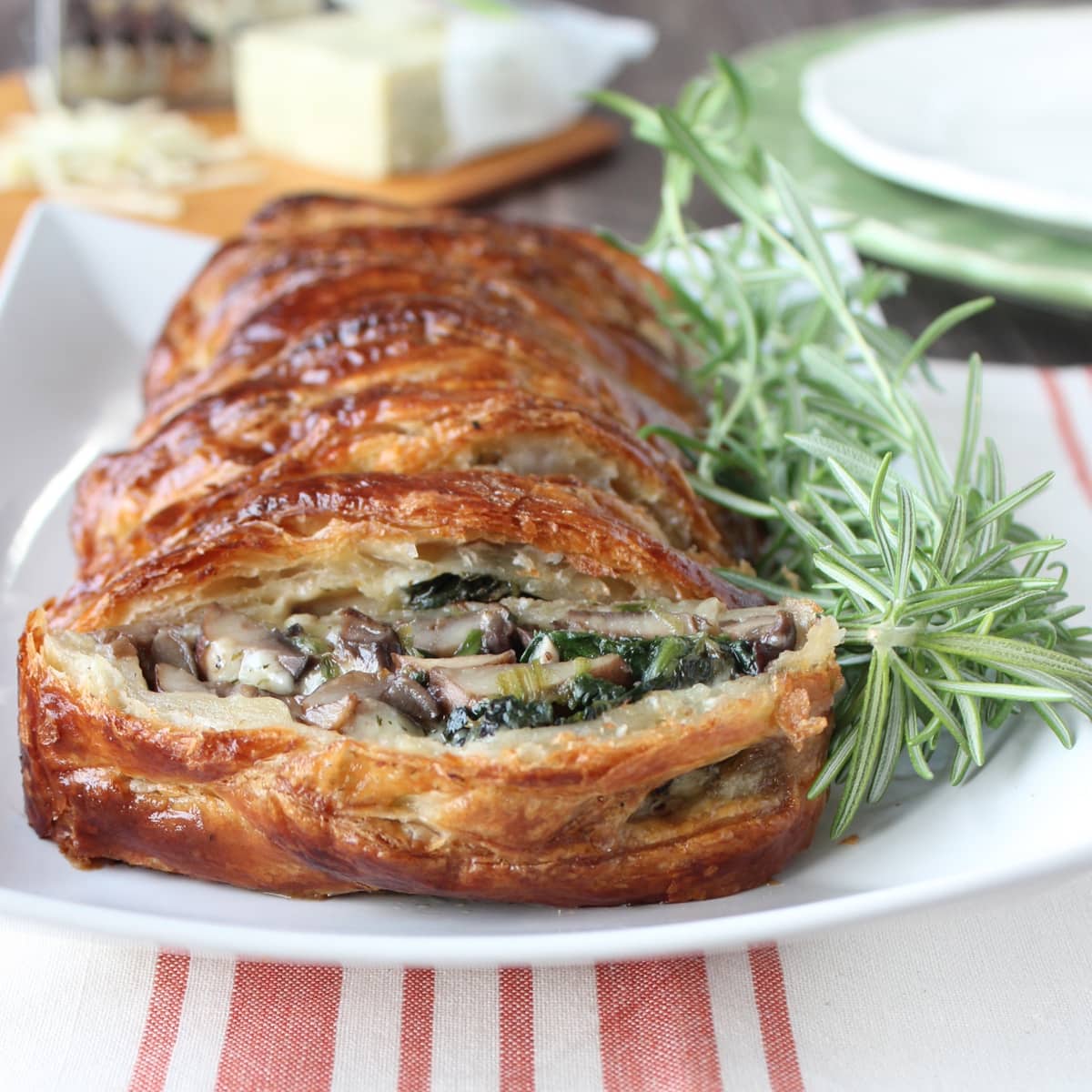 baked braided puff pastry on plate with fresh rosemary