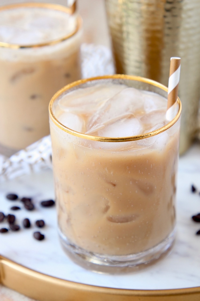 Long Island Iced Coffee cocktail in gold rimmed glass with gold and white striped straw