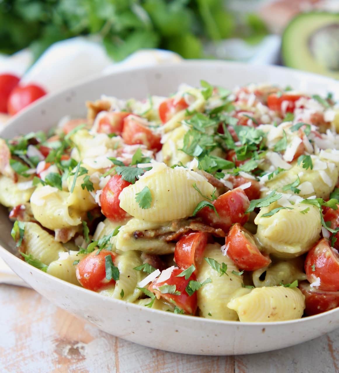 Pasta salad in bowl with diced tomatoes and bacon