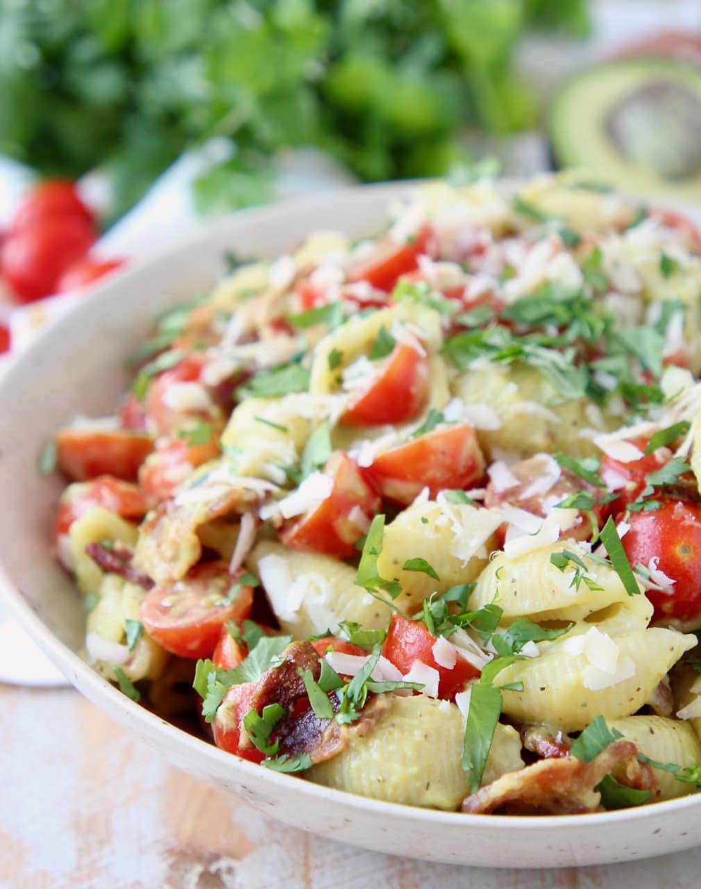 Pasta salad in bowl with bacon, tomatoes and parmesan cheese