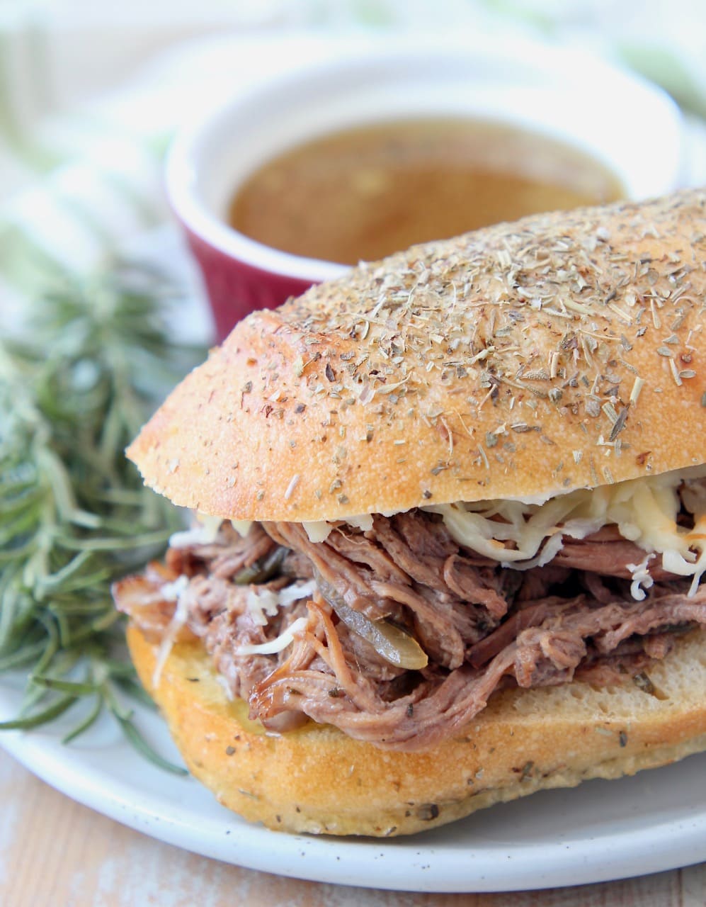 Shredded tri tip sandwich on plate with fresh rosemary