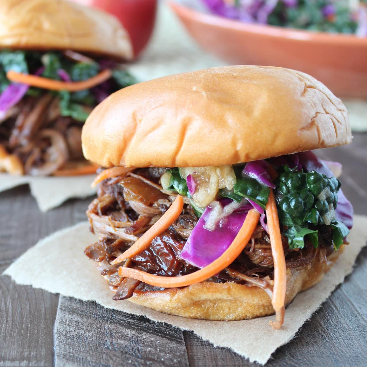 shredded bbq brisket and coleslaw in between two hamburger buns