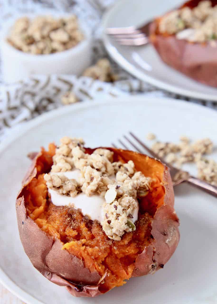 Roasted sweet potato on plate filled with yogurt and granola