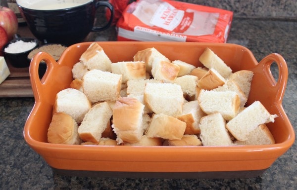 cubed bread in orange baking dish