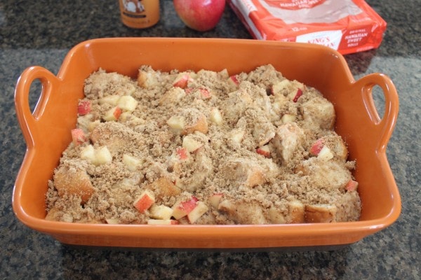 unbaked bread pudding in baking dish topped with diced apples and brown sugar crumble
