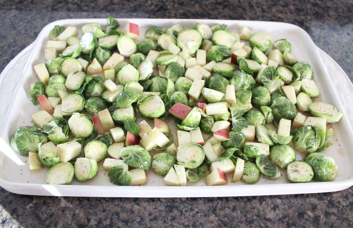 brussels sprouts and diced apples in an even layer on a baking sheet