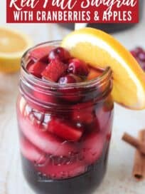 Sangria in glass with cranberries and orange wedge on the side