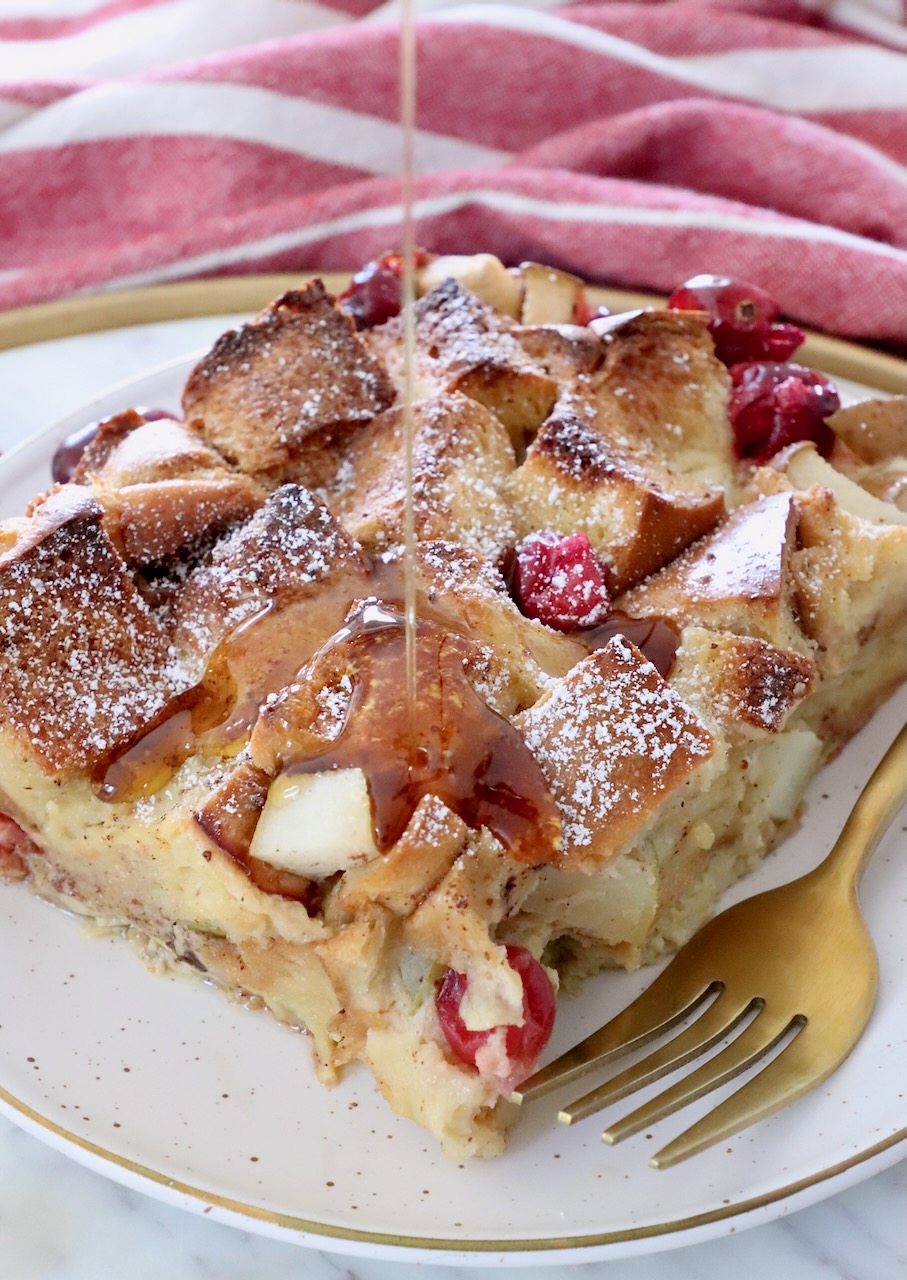 syrup poured over a slice of french toast casserole on a plate with a fork