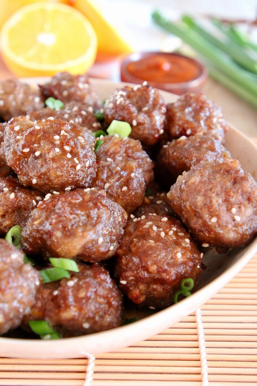 Chinese meatballs in bowl with diced green onions and sesame seeds