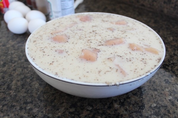 raw chopped chicken soaking in a bowl of milk