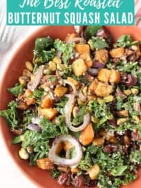 Tossed kale salad in bowl with cubes of roasted squash